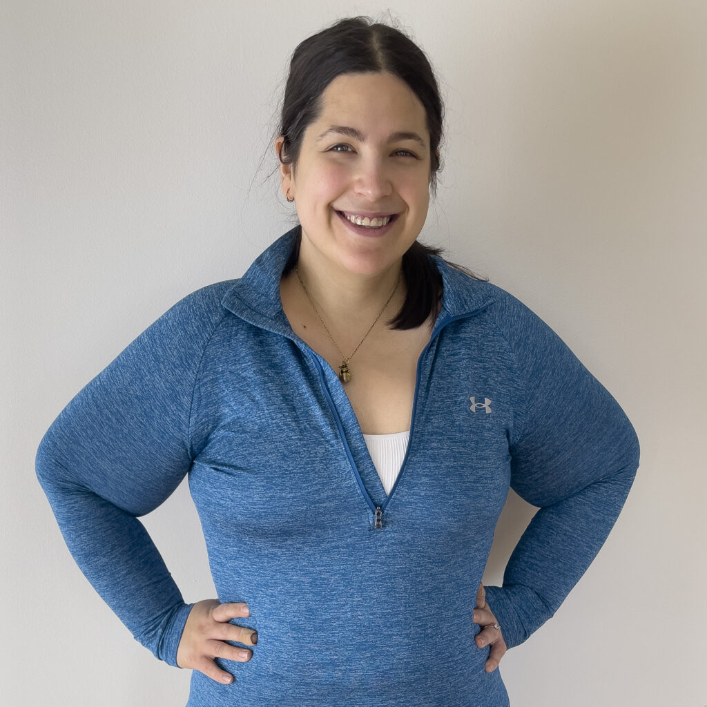 Square photo of Liz in a blue long sleeved quarter zip shirt.